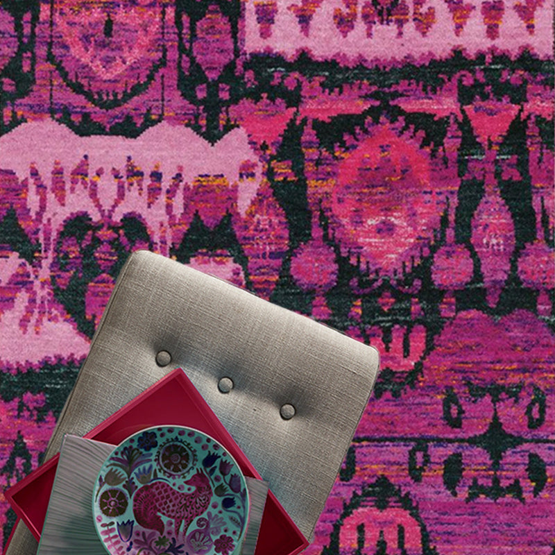 magenta colored rug with chair and pink plate and book